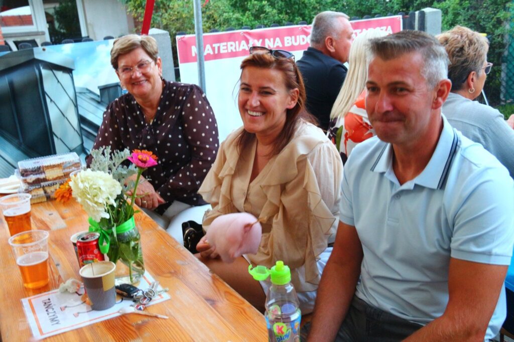 Uśmiechnięci parafianie przy biesiadnym stole