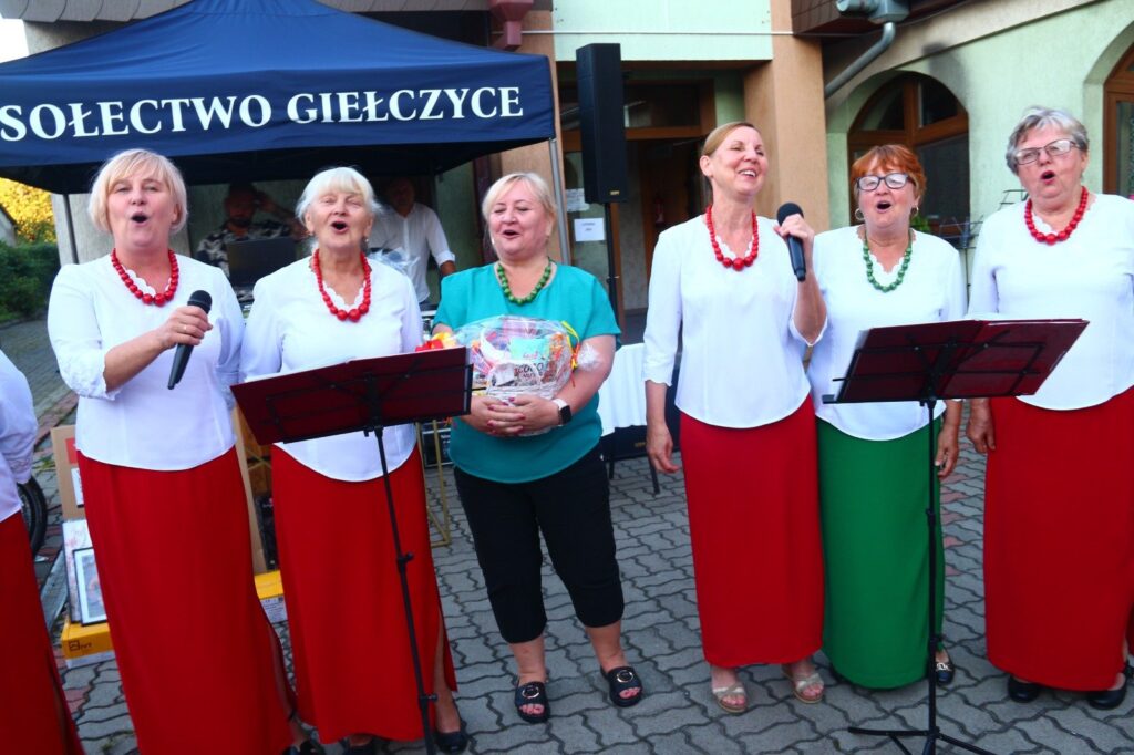 Zespół w ludowych strojach śpiewa dla uczestników festynu